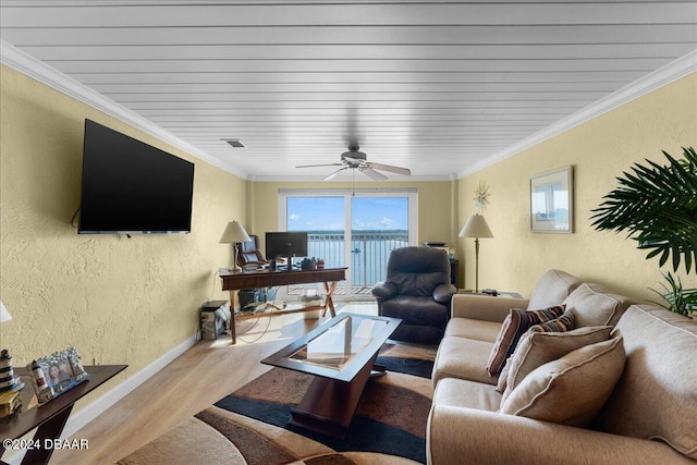 living room featuring ceiling fan, ornamental molding, and light hardwood / wood-style flooring