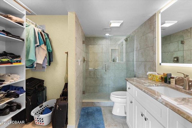 bathroom with vanity, toilet, an enclosed shower, and tile patterned flooring