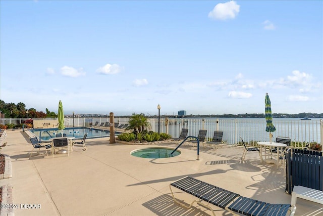 view of pool featuring a water view, a community hot tub, and a patio area