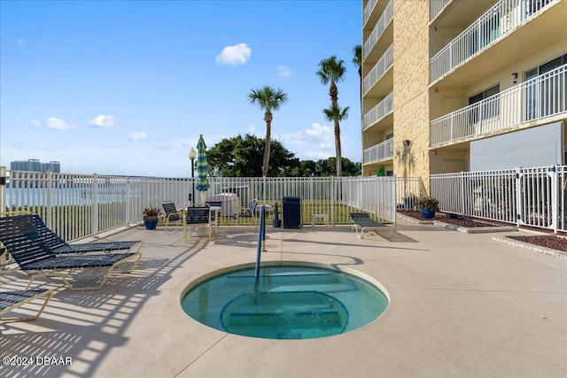 view of swimming pool with a patio area and a hot tub