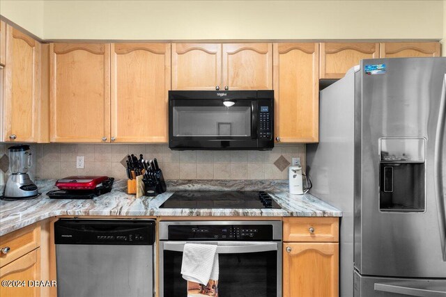 kitchen with light wood-type flooring, decorative backsplash, black appliances, light brown cabinets, and a textured ceiling