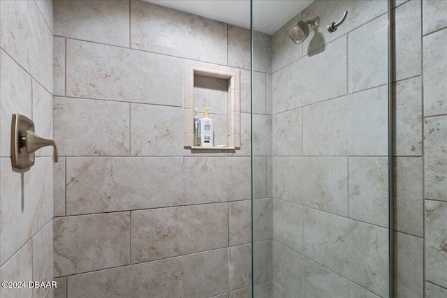 interior details featuring tiled shower