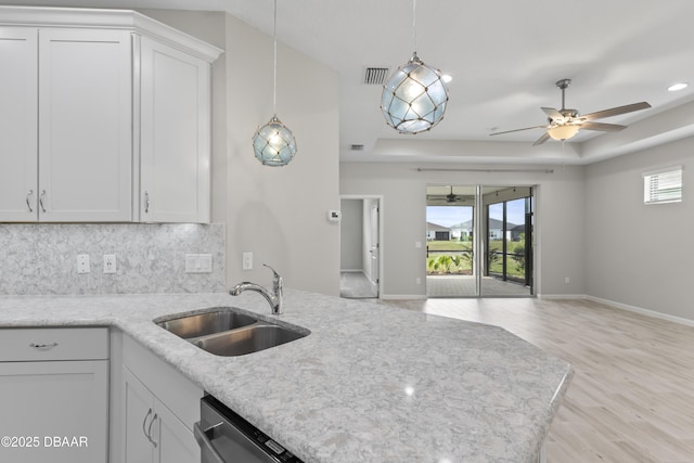 586 Lost Shaker Way, Daytona Beach, FL 32124 - kitchen featuring a sink, light wood finished floors, open floor plan, a tray ceiling, and tasteful backsplash