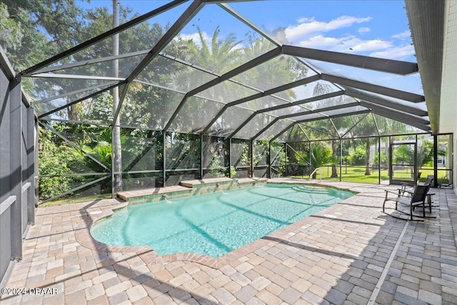 view of pool featuring glass enclosure, a patio area, and pool water feature