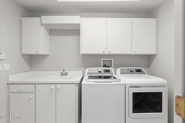 washroom with cabinets, sink, and washer and clothes dryer