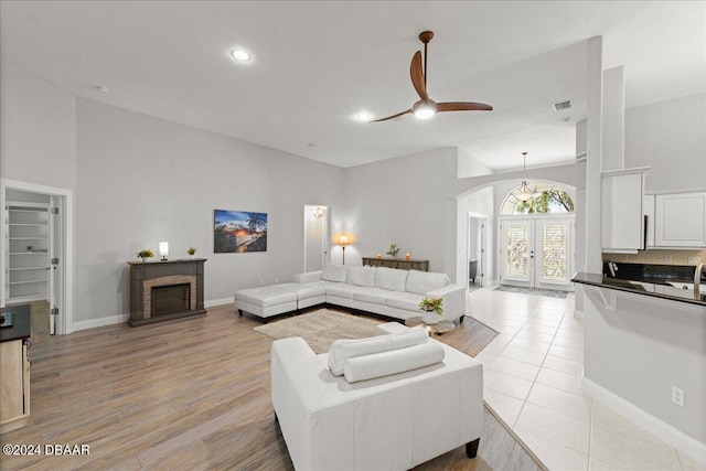 living room with ceiling fan, french doors, and light hardwood / wood-style floors