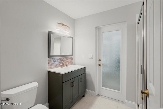 bathroom with toilet, backsplash, vanity, and tile patterned flooring