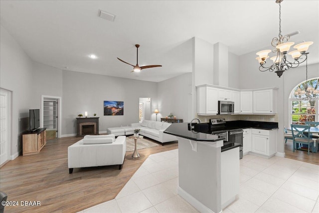 kitchen featuring light hardwood / wood-style flooring, kitchen peninsula, appliances with stainless steel finishes, and white cabinets