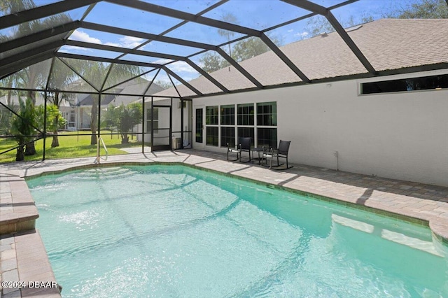 view of pool with glass enclosure and a patio