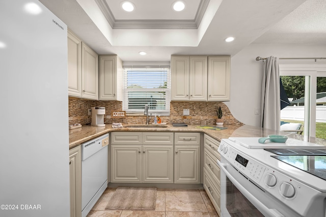 kitchen featuring tasteful backsplash, crown molding, a raised ceiling, sink, and white appliances