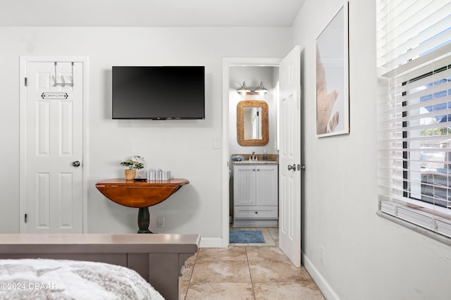 tiled bedroom with sink and ensuite bath