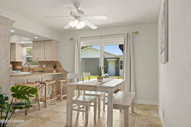 dining area with a textured ceiling, ceiling fan, and sink