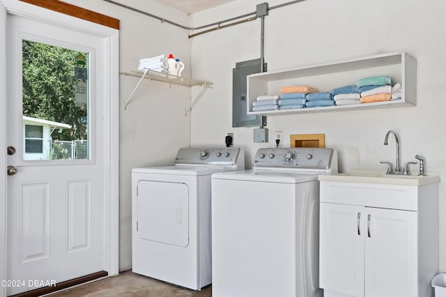 washroom featuring sink, electric panel, cabinets, and washing machine and clothes dryer