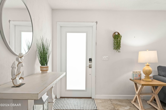 doorway to outside with light tile patterned floors