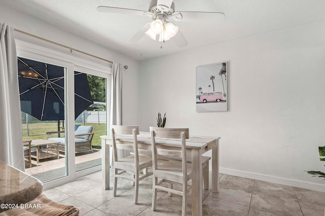 dining space featuring light tile patterned flooring, a textured ceiling, and ceiling fan