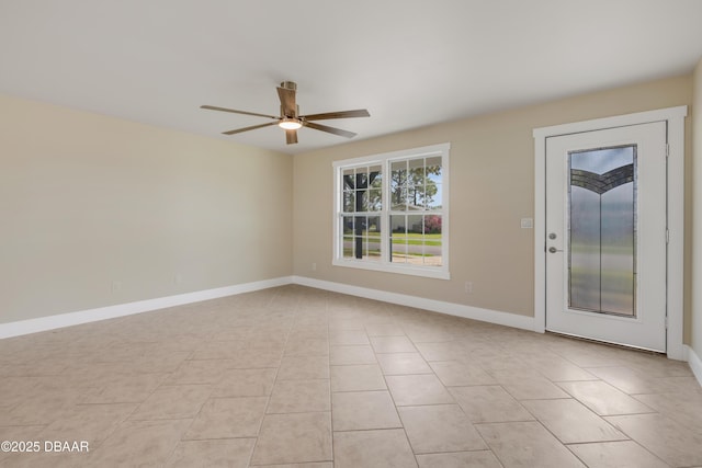 spare room with ceiling fan, baseboards, and light tile patterned flooring