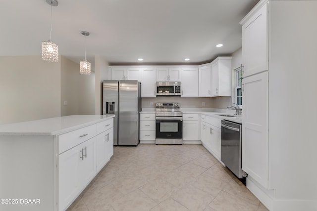 kitchen with recessed lighting, a sink, white cabinets, light countertops, and appliances with stainless steel finishes