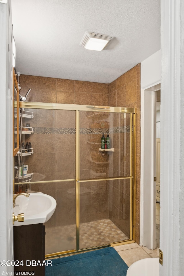 39 Brooks Dr, Ormond Beach, FL 32176 - bathroom with a stall shower, tile patterned floors, vanity, a textured ceiling, and toilet