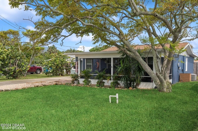 view of front facade with a sunroom and a front yard