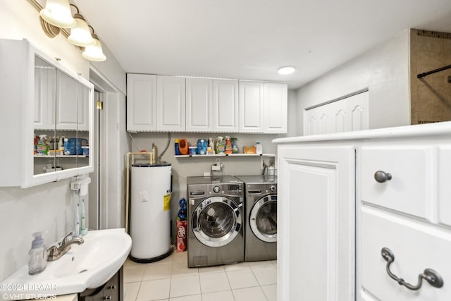 laundry room with light tile patterned flooring, water heater, cabinets, sink, and independent washer and dryer