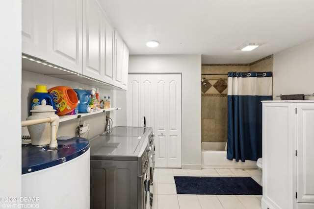 laundry area featuring water heater, light tile patterned floors, and independent washer and dryer