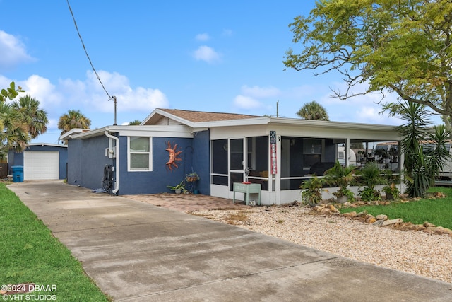 39 Brooks Dr, Ormond Beach, FL 32176 - view of front of property with a sunroom, driveway, a garage, an outdoor structure, and stucco siding