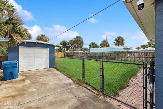 39 Brooks Dr, Ormond Beach, FL 32176 - view of yard featuring an outbuilding, concrete driveway, a garage, and a gate