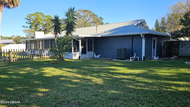 back of house with a yard, central AC unit, and a sunroom