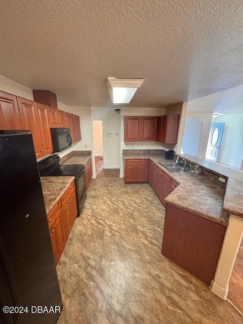 kitchen featuring sink, a textured ceiling, and black appliances