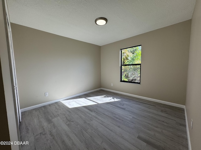 unfurnished room featuring wood-type flooring and a textured ceiling