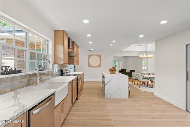 kitchen featuring light stone countertops, appliances with stainless steel finishes, pendant lighting, and backsplash