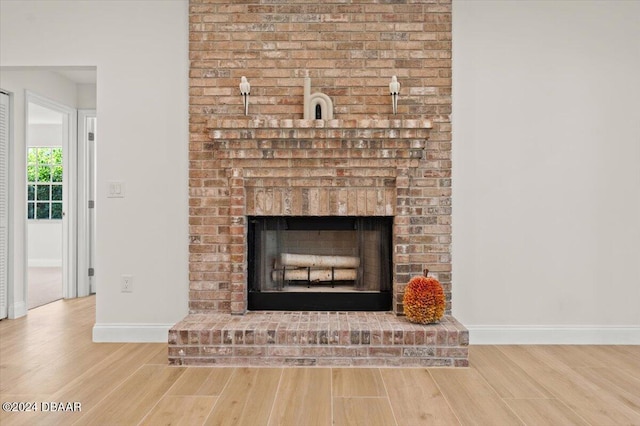 interior details with hardwood / wood-style floors and a brick fireplace