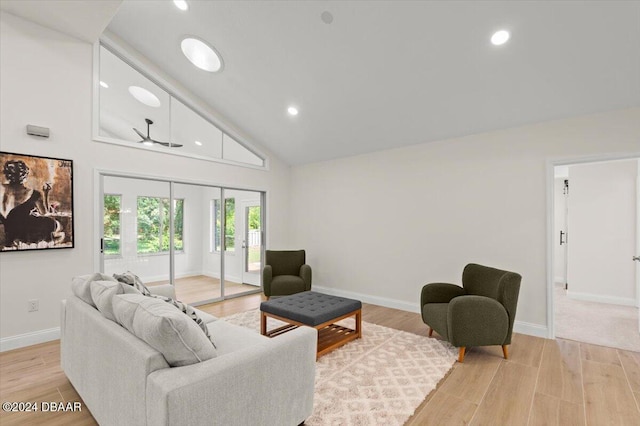 living room featuring high vaulted ceiling and light hardwood / wood-style floors