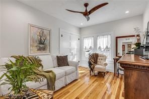 living room featuring ceiling fan and light hardwood / wood-style flooring