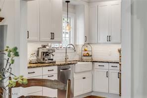 kitchen featuring dishwasher, white cabinets, decorative light fixtures, and sink