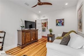 living room featuring wood-type flooring and ceiling fan