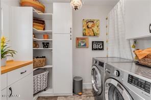 laundry area featuring separate washer and dryer and cabinets