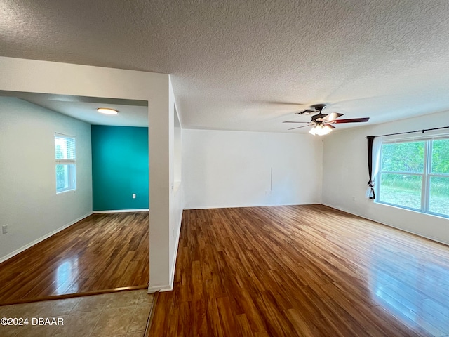 interior space with hardwood / wood-style floors, a wealth of natural light, ceiling fan, and a textured ceiling