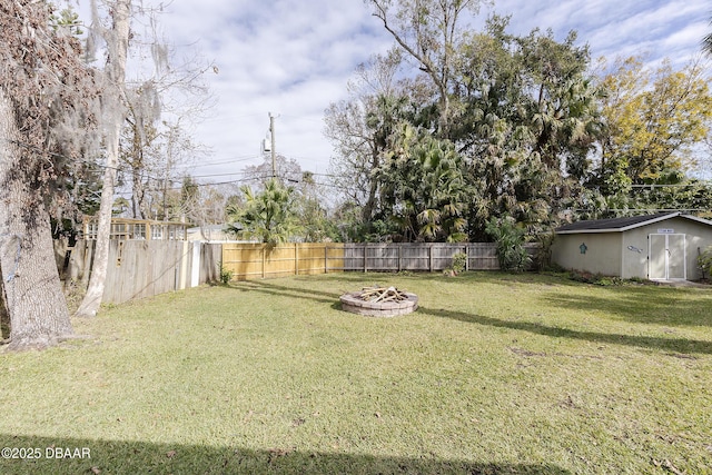 view of yard featuring a storage unit and an outdoor fire pit