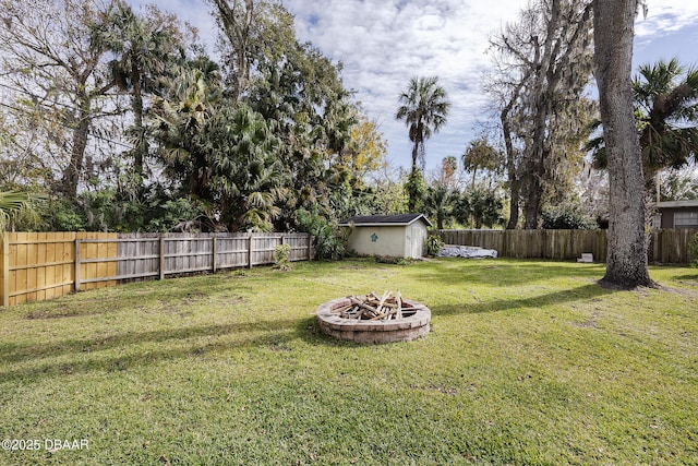 view of yard featuring a storage unit and a fire pit