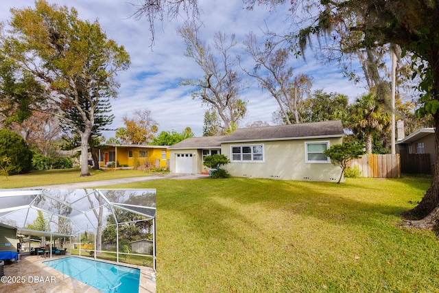 back of property featuring a yard, a garage, and glass enclosure