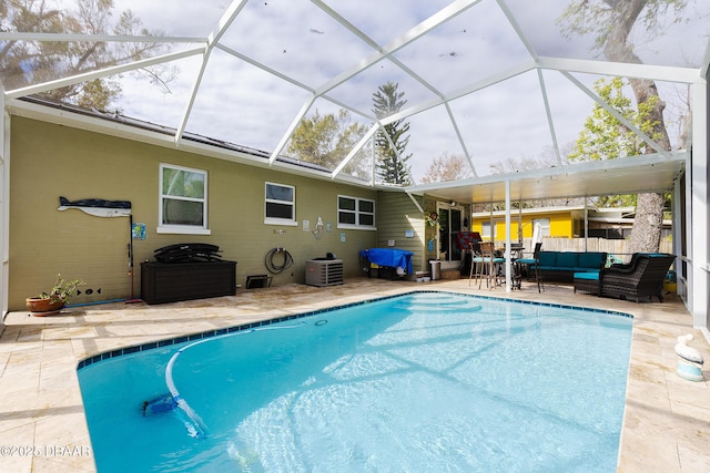 view of swimming pool with cooling unit, outdoor lounge area, a patio, and a lanai