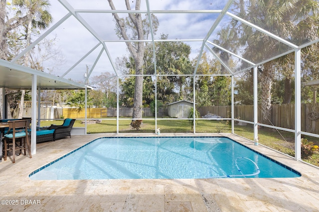 view of swimming pool with a patio, a lanai, a yard, and a shed