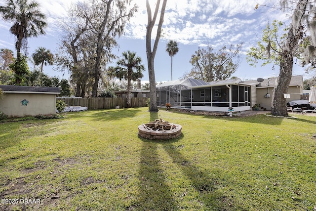 view of yard featuring a sunroom and an outdoor fire pit