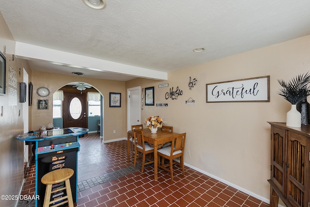 dining space featuring ceiling fan and a textured ceiling