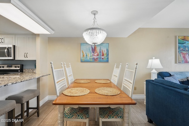2626 S Atlantic Ave Unit 505, Daytona Beach, FL 32118 - dining room featuring light wood-style floors, baseboards, and a chandelier