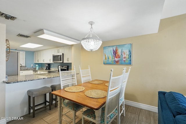 2626 S Atlantic Ave Unit 505, Daytona Beach, FL 32118 - dining space with wood finished floors, baseboards, and a chandelier