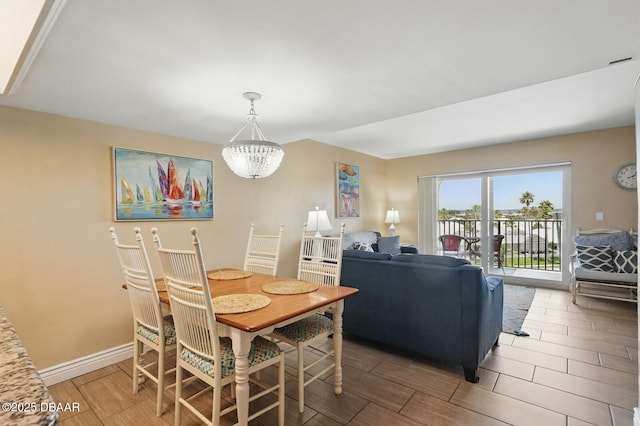 2626 S Atlantic Ave Unit 505, Daytona Beach, FL 32118 - dining space featuring wood finish floors, a chandelier, and baseboards