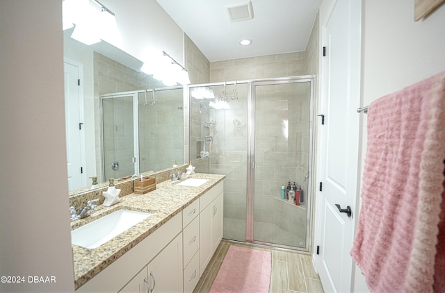 bathroom featuring vanity and a shower with door