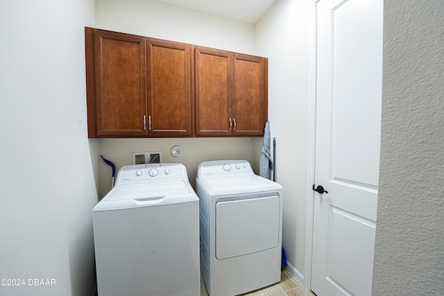 washroom featuring cabinets and washing machine and dryer